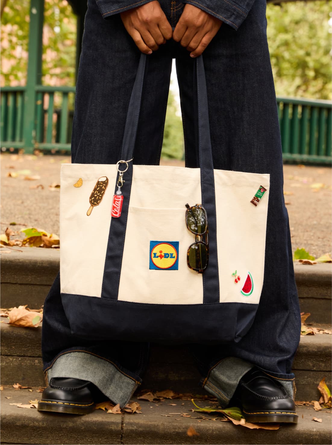 A shopper holding a Lidl tote decorated with food badges